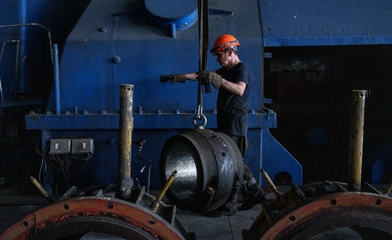 A worker at the Kurakhove power plant works to disassemble and move critical parts earlier this year after the plant could not longer operate.