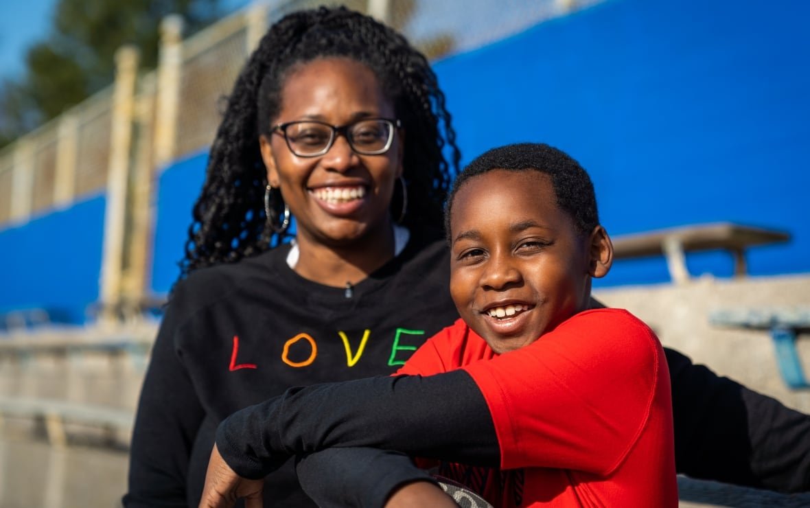 A mother and son pose for a photo.